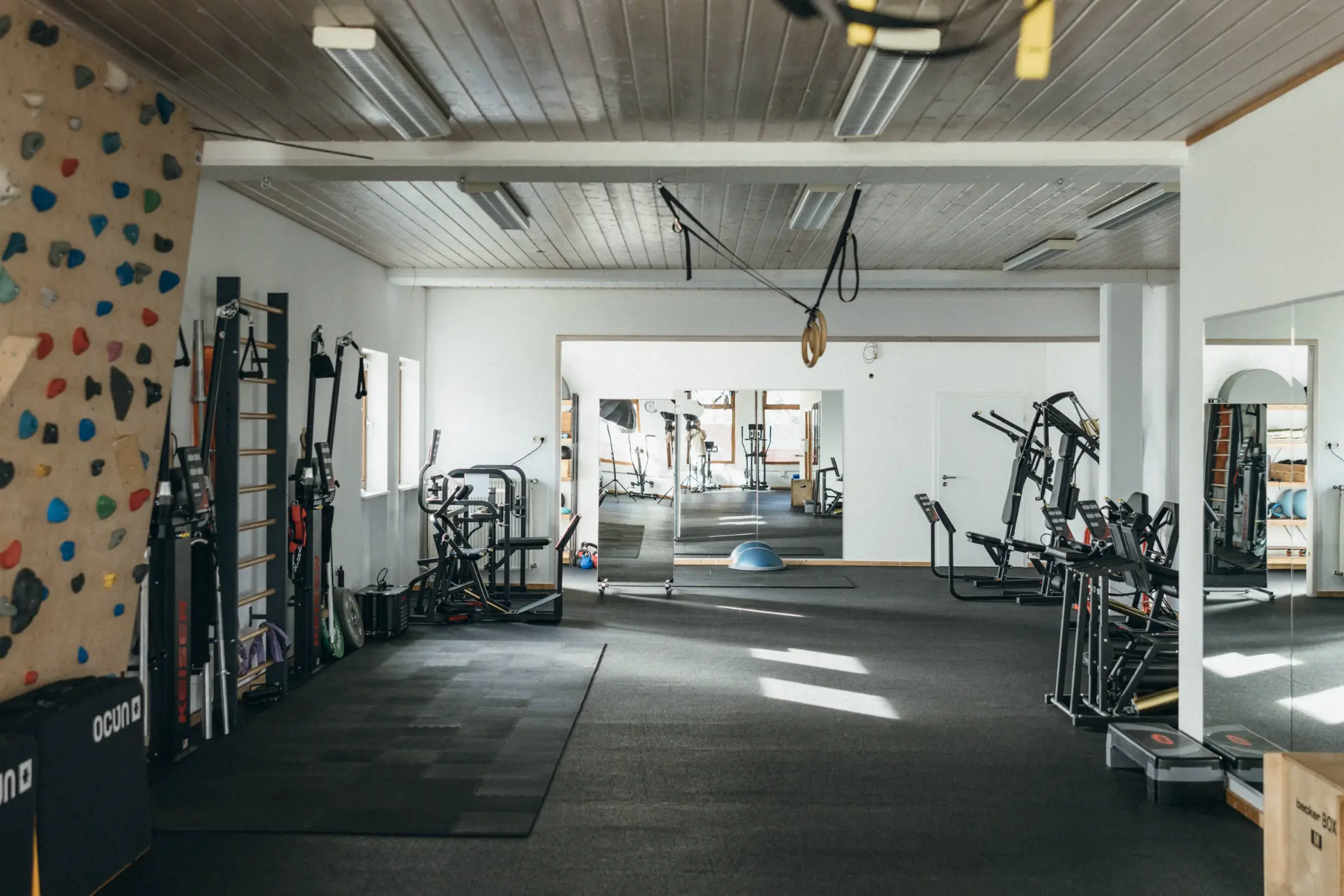 Panorama des Trainingsraums mit Kletterwand und Trainingsgeräten