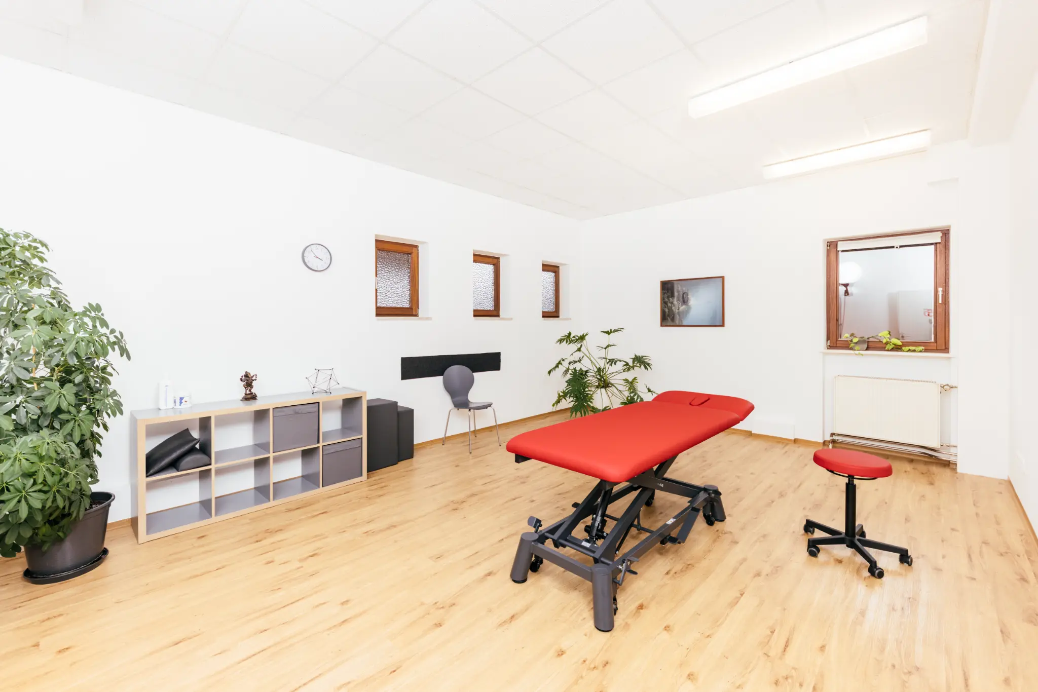 Behandlungsraum mit roter Therapieliege