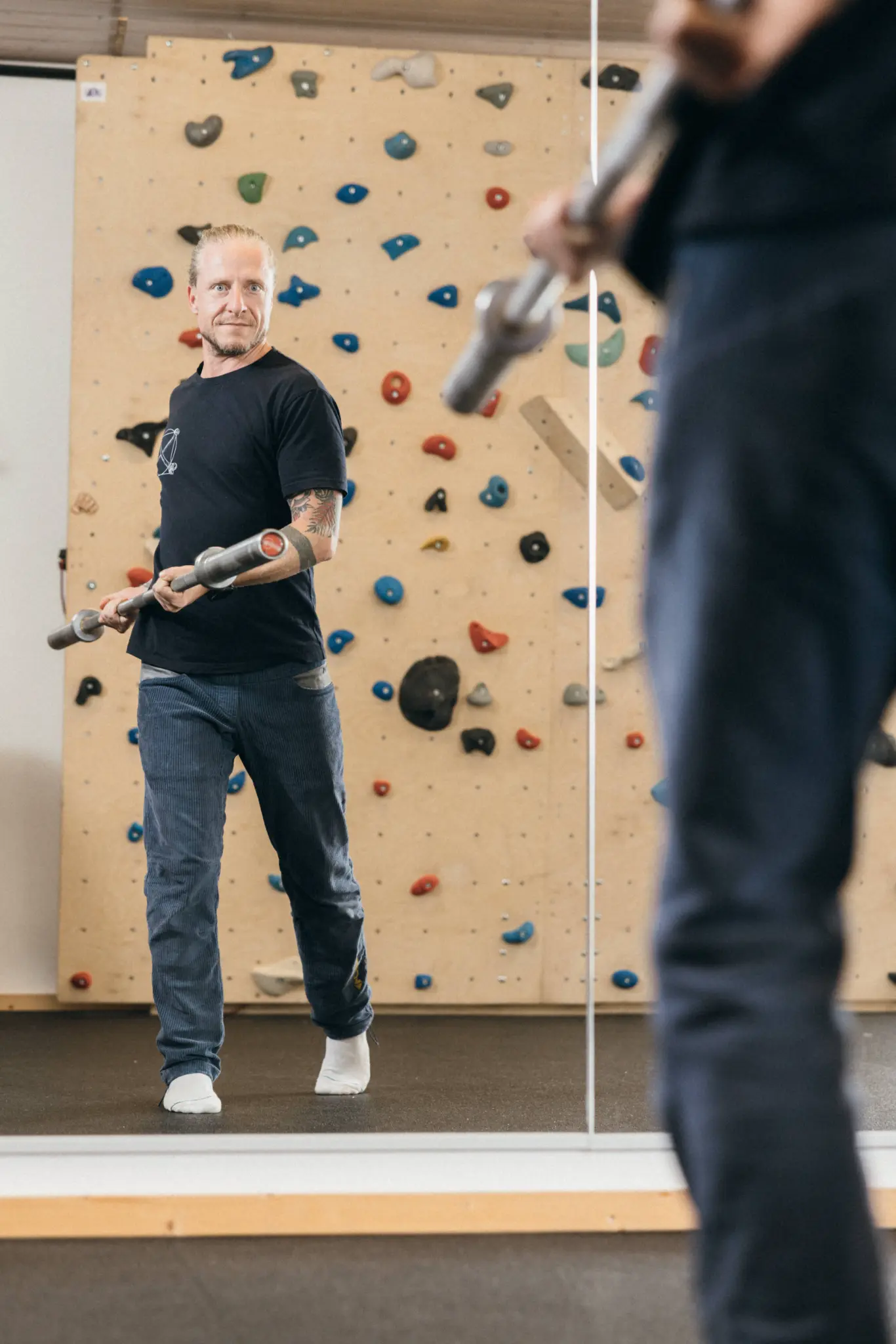 Andreas mit Trainingsstange vor der Kletterwand