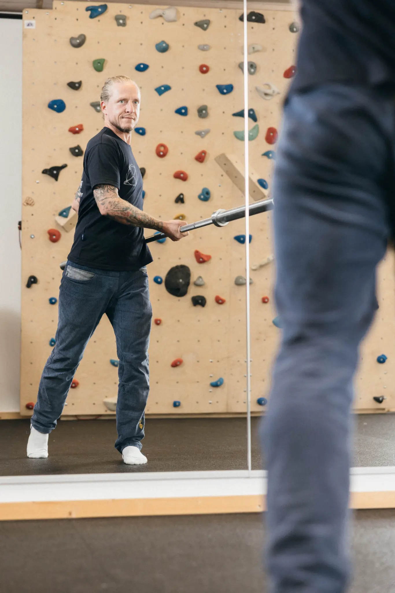 Andreas mit Trainingsstange vor der Kletterwand